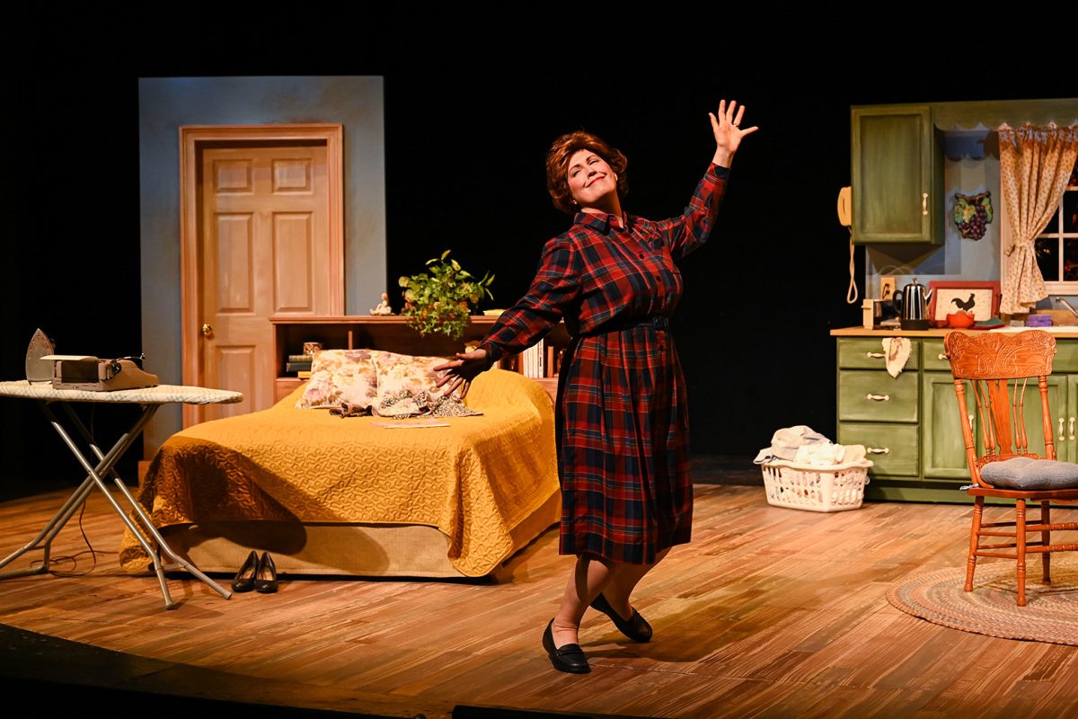 Woman on stage in an apartment setting. Dancing with arms and jazz hands.