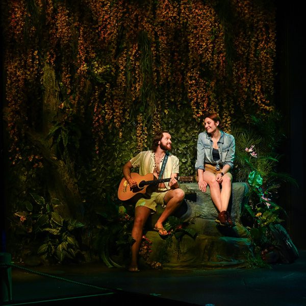 Man serenading women with guitar.