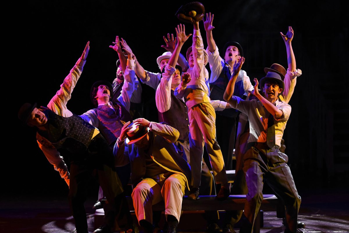 Ragtime cast with all men reaching their arms in the air.